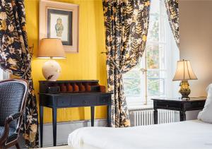 um quarto com uma cama e um candeeiro sobre uma mesa em Château d'Ygrande - Teritoria em Ygrande