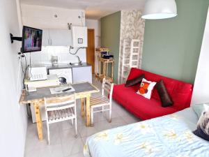 エンプリアブラバにあるEstudio Biarritz 618のリビングルーム(キッチン、赤いソファ付)