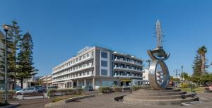 a large building with a clock in front of it at Kos Divine Hotel & Suites in Kos