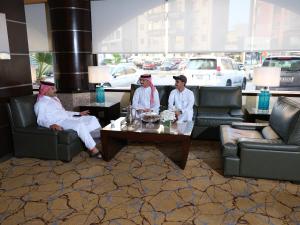 a group of three people sitting in a living room at Boudl AL Salmiya بودل الكويت السالمية in Kuwait