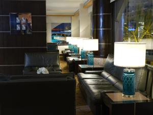 a lobby with leather couches and tables and lamps at Boudl Salmiya, Kuwait - بودل السالمية الكويت in Kuwait