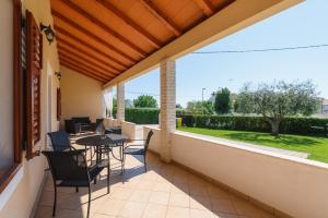 a patio with a table and chairs on a balcony at MIMA house with apartments in Savudrija +25 photos