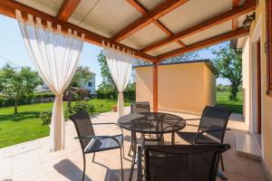 a patio with a glass table and chairs at MIMA house with apartments in Savudrija