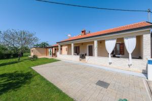 a house with a patio in a yard at MIMA house with apartments in Savudrija