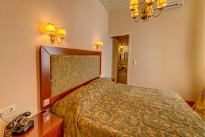 a bedroom with a bed and a phone on a table at Apollonion Palace in Ermoupoli