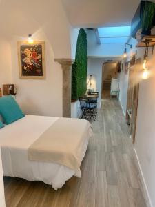 a hotel room with a bed and a dining room at Casa Via De La Plata in Cáceres