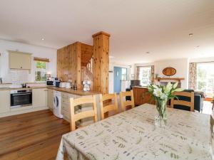 una cocina con una mesa con un jarrón de flores. en Lough View Cottage, en Carrigart