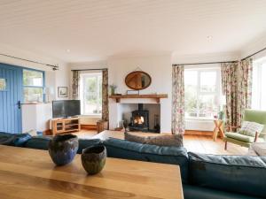 a living room with a blue couch and a fireplace at Lough View Cottage in Carrigart