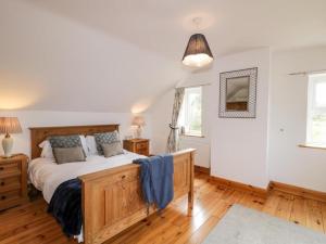 1 dormitorio con 1 cama grande de madera en una habitación en Lough View Cottage, en Carrigart
