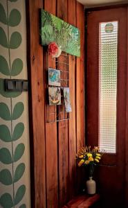 a room with a wooden wall with a window and a vase of flowers at Retro in Tolmin