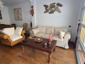 ein Wohnzimmer mit einer Couch und einem Couchtisch in der Unterkunft Suites Beach House in Playa de las Americas