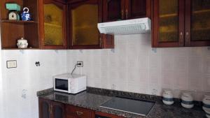 a kitchen counter with a microwave and a sink at CUCA in Muxia