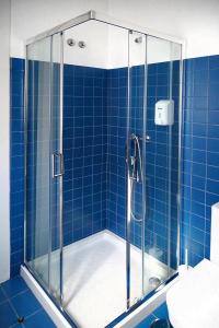 La salle de bains est pourvue d'une douche et de murs carrelés bleus. dans l'établissement Citybreak-apartments Bolhao, à Porto