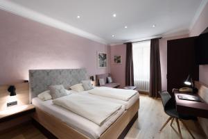 um quarto com uma cama grande e uma secretária em Altstadthotel Kasererbräu em Salzburgo