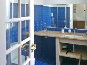 La salle de bains bleue est pourvue d'un lavabo et d'un miroir. dans l'établissement Citybreak-apartments Bolhao, à Porto