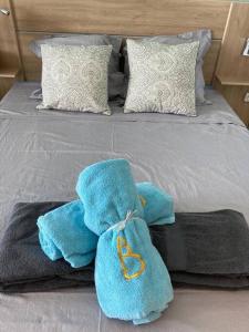 un letto con asciugamani e cuscini blu; di Studio vue mer et rocher du Diamant Antilles a Le Diamant