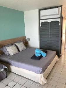 una camera da letto con un letto e un asciugamano blu di Studio vue mer et rocher du Diamant Antilles a Le Diamant