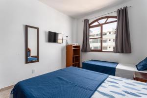 1 dormitorio con 2 camas y ventana en Prainha en Arraial do Cabo