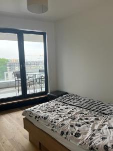 sypialnia z łóżkiem i widokiem na balkon w obiekcie Kraków Grzegórzecka Wiślane Tarasy w Krakowie