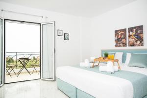 1 dormitorio con 1 cama grande y balcón en Athinais Suites en Hersonissos