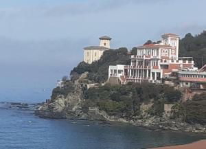 a large building on top of a hill next to the ocean at Castiglioncello Suite in Castiglioncello
