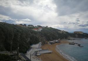 a sandy beach with houses on a hill next to the water at Castiglioncello Suite in Castiglioncello