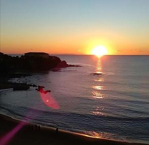 a sunset on the beach with the sun setting at Castiglioncello Suite in Castiglioncello