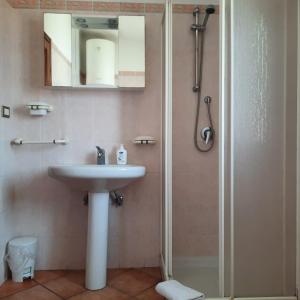 łazienka z umywalką i prysznicem z lustrem w obiekcie La casa di Alessia w mieście Santa Teresa Gallura