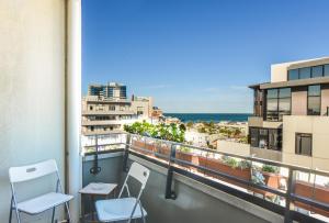 a balcony with two chairs and a view of the ocean at StayCentral - Spacious Seaviews Port Melbourne in Melbourne