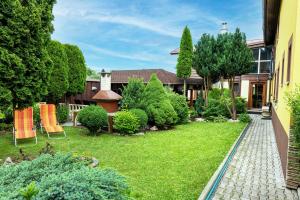 a garden with chairs and trees in front of a house at Apartmán u Vierky in Veľká Lomnica