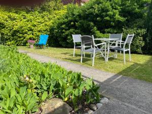 3 sedie e un tavolo in giardino di Maison avec jardin a Béthune