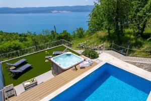 una piscina su una terrazza con vista sull'acqua di Villa Maruncela with sea and island views, 5 bedrooms, private pool, gym a Lokva Rogoznica