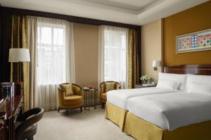 um quarto de hotel com uma cama e uma cadeira em The Beaumont Hotel em Londres