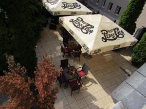 einen Blick über ein Restaurant mit Stühlen und Sonnenschirmen in der Unterkunft Szent Gellért Hotel in Székesfehérvár