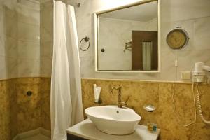 a bathroom with a sink and a mirror and a shower at New Times Home & Hotels Near Metro Station Athens Center in Athens