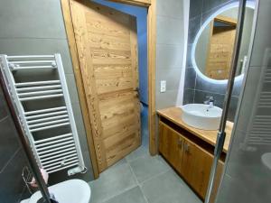 een badkamer met een wastafel en een spiegel bij Serre chevalier, Chantemerle, pied des pistes et du bike Park in Saint-Chaffrey