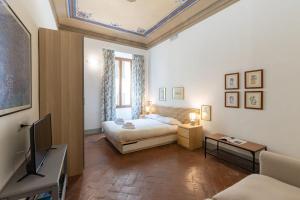 une chambre avec un lit et une télévision dans une pièce dans l'établissement PITTI Suite, à Florence