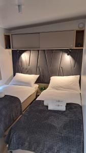 um quarto com 2 camas e uma grande cabeceira em Mobile Home Sole em Biograd na Moru