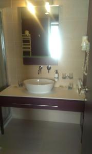 uma casa de banho com um lavatório e um espelho em Szent Gellért Hotel em Székesfehérvár