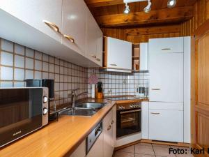 a kitchen with white cabinets and a sink at Ferienhof Kienbronnerhof in Schiltach