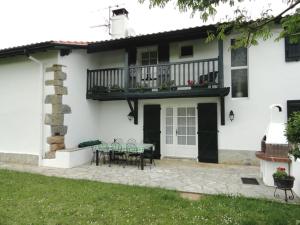 a white house with a patio and a balcony at Maison etxebarnia cote in Mendive