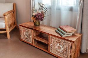 a wooden table with a vase of flowers and books at Ōrigins Hotel Boutique - Adults Only in Artá