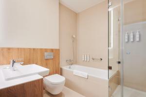 a bathroom with a sink and a toilet and a shower at Courtyard by Marriott Warsaw Airport in Warsaw
