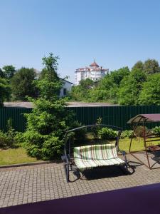 un banc assis sur une terrasse à côté d'une clôture dans l'établissement Villa Kameliya, à Trouskavets