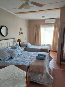 een slaapkamer met 2 bedden en een plafondventilator bij At Home Apartments in Mokopane