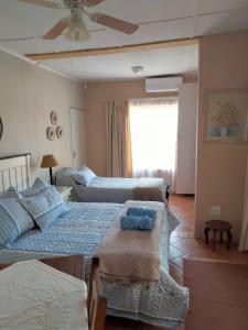 sala de estar con 2 camas y ventilador de techo en At Home Apartments, en Mokopane