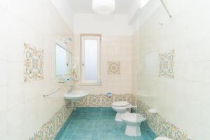 a bathroom with two toilets and a sink at Hotel America in Marina di Camerota