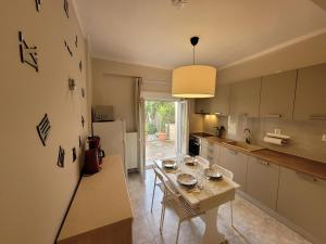 a kitchen with a table and a dining room at Anris & Dianas Dom - In a quiet part of the center in Kallithea Halkidikis