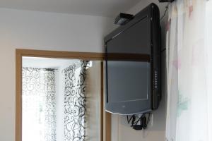 uma televisão pendurada numa parede ao lado de uma janela em Apartments Teo em Opatija