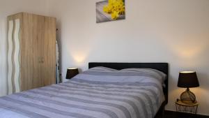 1 dormitorio con 1 cama y 2 lámparas. en Apartments Teo en Opatija